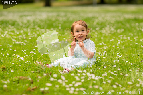 Image of happy little baby girl at park in summer