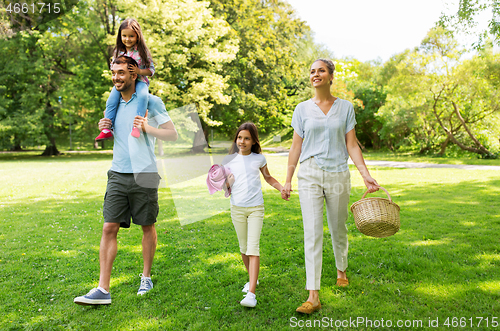 Image of family with picnic basket walking in summer park