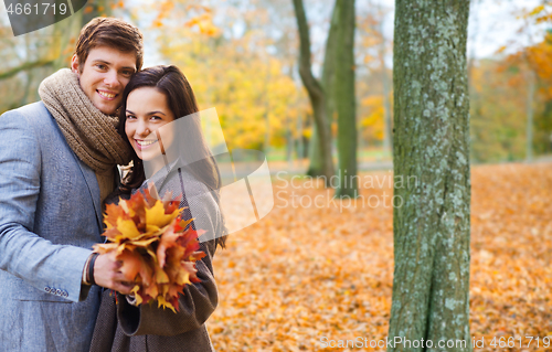 Image of smiling couple hugging in autumn park