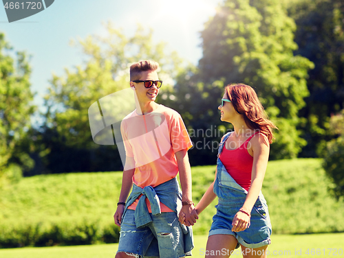 Image of happy teenage couple walking at summer park