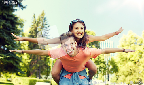 Image of happy teenage couple having fun at summer park