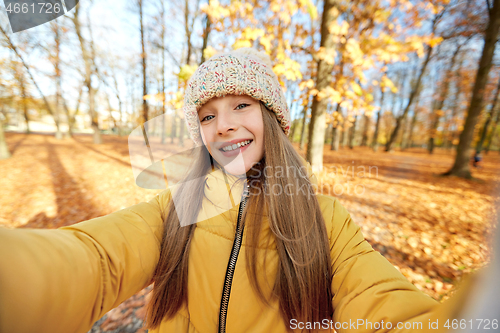 Image of happy girl taking selfie at autumn park