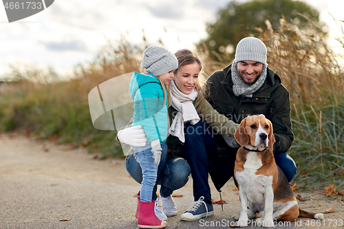 Image of happy family with beagle dog outdoors in autumn