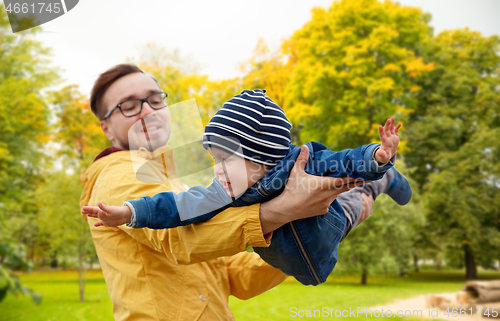 Image of father with son playing and having fun in autumn