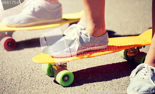 Image of close up of female feet riding short skateboard