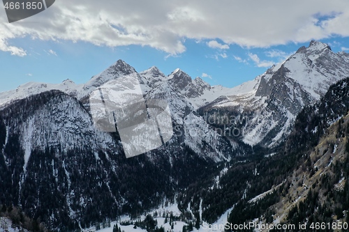 Image of aerial snow covered mountain peaks in alps at winter 