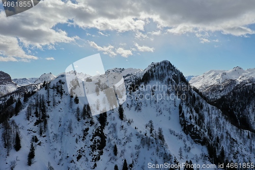 Image of aerial snow covered mountain peaks in alps at winter 