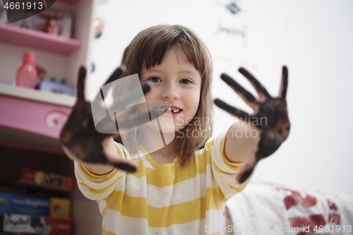 Image of cute little girl at home painting with hands