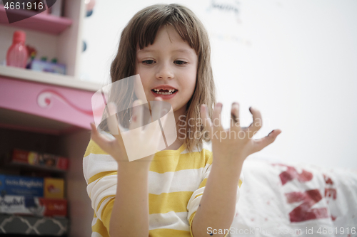 Image of cute little girl at home painting with hands