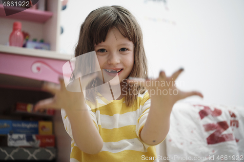 Image of cute little girl at home painting with hands