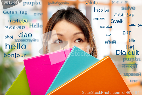 Image of asian woman or student hiding behind notebooks