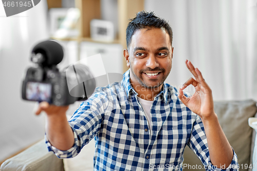 Image of male video blogger with camera blogging at home