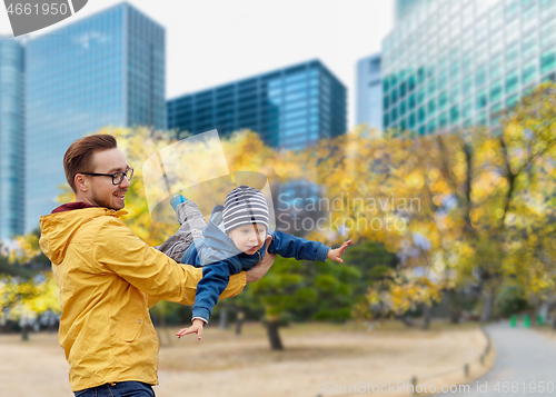 Image of father with son having fun in autumn tokyo city