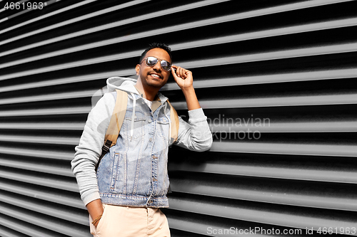 Image of indian man in sunglasses with backpack on street