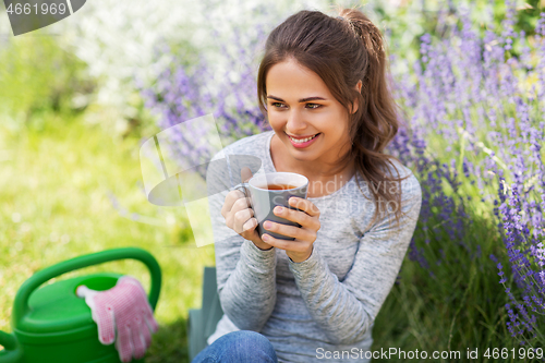 Image of young woman drinking tea at summer garden