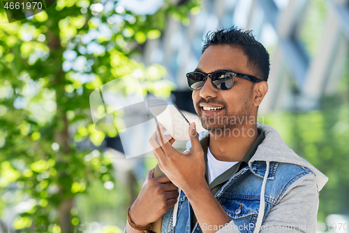 Image of man recorving voice message on smartphone in city