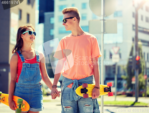 Image of teenage couple with skateboards on city street