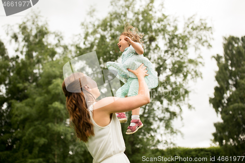 Image of happy mother with baby daughter at summer park