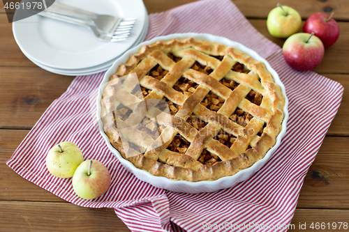 Image of apple pie in baking mold on wooden table