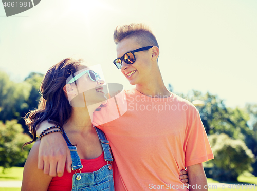 Image of happy teenage couple looking at each other in park