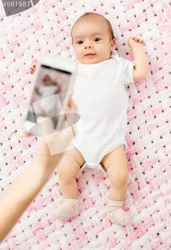 Image of sweet baby girl being photographed by smartphone