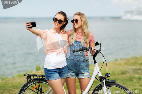 Image of teenage girls with bicycle taking selfie in summer