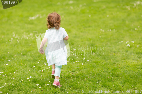 Image of happy little baby girl running at park in summer