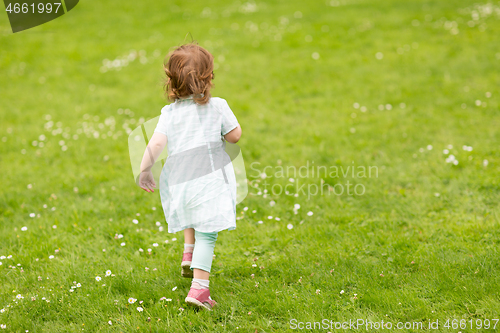 Image of happy little baby girl running at park in summer