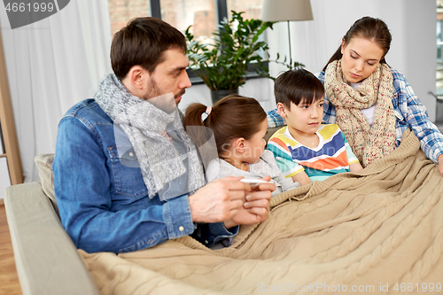 Image of family with ill children having fever at home