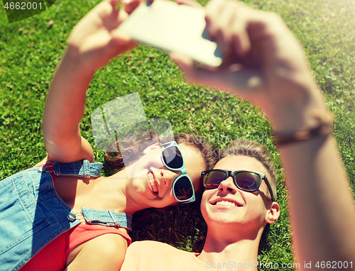 Image of happy couple taking selfie on smartphone at summer