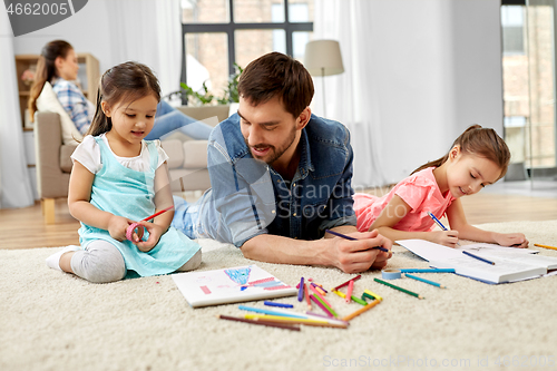 Image of father spending time with little daughters at home