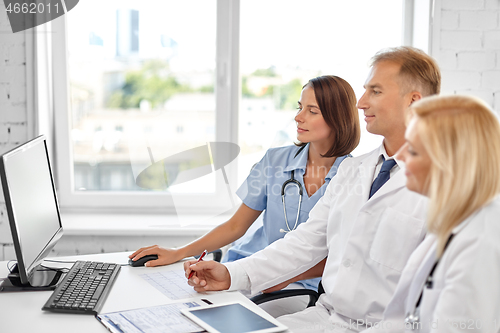 Image of group of doctors with computer at hospital