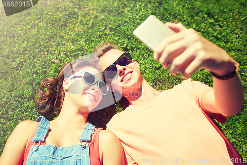 Image of happy couple taking selfie on smartphone at summer