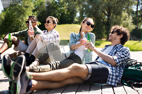 Image of friends drinking beer and cider in summer park