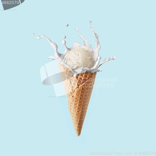 Image of Fresh natural ice-cream in a corn with milk splash against pastel blue background.