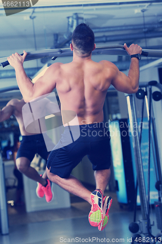 Image of handsome man exercising at the gym