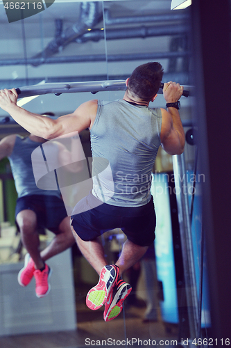 Image of handsome man exercising at the gym