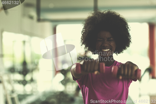 Image of woman working out in a crossfit gym with dumbbells