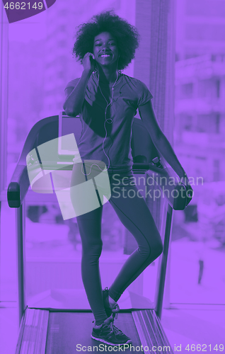 Image of afro american woman running on a treadmill