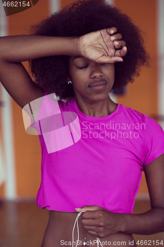 Image of afro american woman running on a treadmill