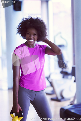 Image of woman working out in a crossfit gym with dumbbells