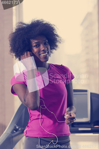 Image of afro american woman running on a treadmill