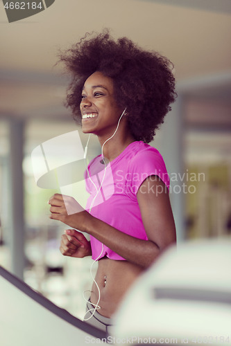 Image of afro american woman running on a treadmill