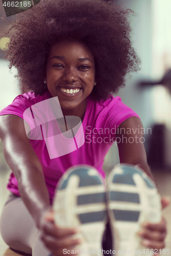 Image of woman in a gym stretching and warming up before workout