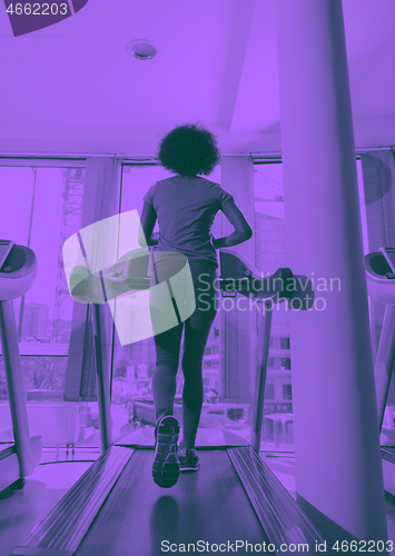 Image of afro american woman running on a treadmill