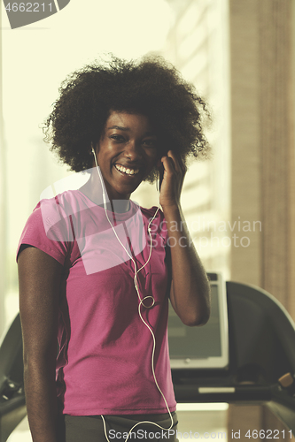 Image of afro american woman running on a treadmill