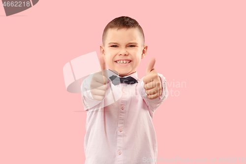 Image of The happy teen boy standing and smiling against pink background.