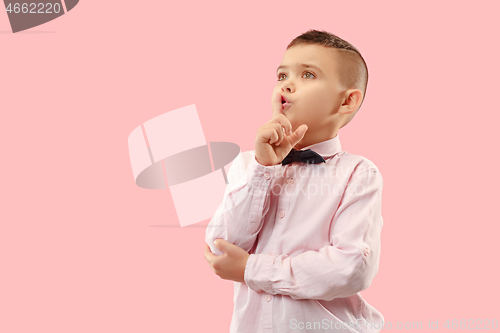 Image of The teen boy whispering a secret behind her hand over pink background