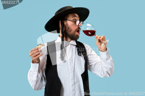 Image of The young orthodox Jewish man with black hat with Hamantaschen cookies for Jewish festival of Purim