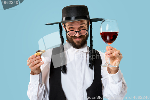 Image of The young orthodox Jewish man with black hat with Hamantaschen cookies for Jewish festival of Purim